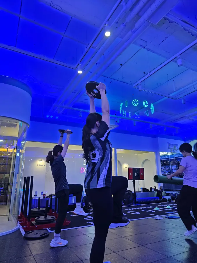 여성 회원들이 원판을 머리 위로 들고 운동하는 장면